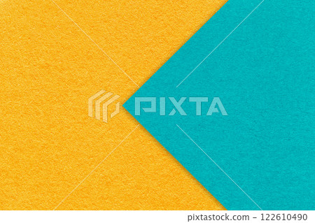 Texture yellow paper background, half two colors with turquoise arrow, macro. Structure craft cerulean cardboard. 122610490