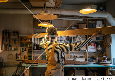 Man in woodworking shop aligns wood beam for cut on table saw with accuracy. Woodshop business Man in woodworking shop aligns wood beam for cut on table saw with accuracy. Woodshop business 122610632