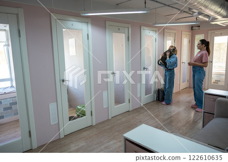 Woman owner hug cat before handing over to female pet sitter. Professional facility for pet lodging Woman owner hug cat before handing over to female pet sitter. Professional facility for pet lodging 122610635