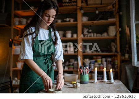 Woman potter molding clay pottery in workshop on wooden table. Small business, ceramics school class 122610636