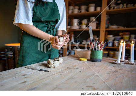 Female potter hands knead clay for craft natural ceramics in workshop. Shape materials in workshop 122610645
