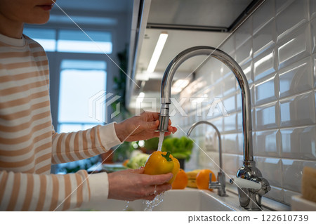Hands washing fresh yellow pepper under tap water. Cooking dinner of natural healthy ingredients 122610739
