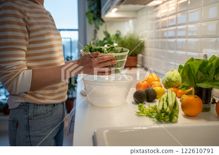 Cooking of quick fresh healthy dinner by prepare of green spinach, celery in hand plastic dryer. 122610791