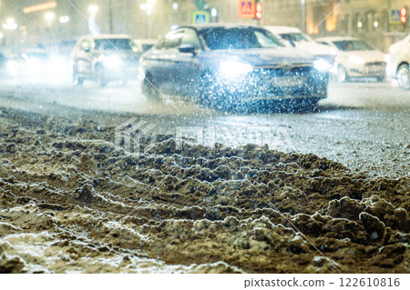 Snowstorm and thaw leave road covered in slushy snow dirt grime. Vehicles crawl through mess Snowstorm and thaw leave road covered in slushy snow dirt grime. Vehicles crawl through mess 122610816