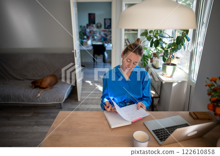 Thoughtful woman of middle age working at laptop from home office. Remote working. Thoughtful woman of middle age working at laptop from home office. Remote working. 122610858