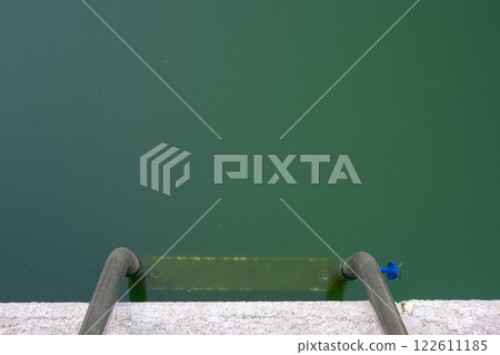 Swimming pool with dirty green water close-up. 122611185