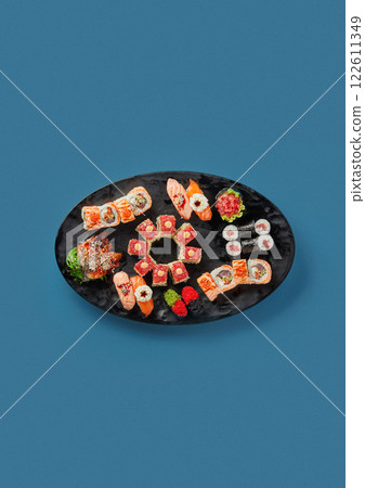 patterned sushi and sashimi on a blue background on a black plate professional cooking by Japanese chef traditional decor a lot of seafood patterned sushi and sashimi on a blue background on a black plate professional cooking by Japanese chef traditional decor a lot of seafood 122611349