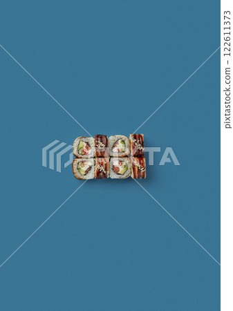 top shot on blue background lies a set of sushi with rice and seafood avocado sushi wrapped in salmon meat red caviar with seaweed professional Japanese cuisine kitchen sushi without shade 122611373