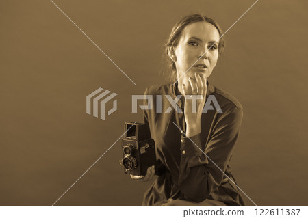 Woman taking picture with old camera Woman taking picture with old camera 122611387