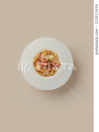 Penne Pasta with Fresh Tomatoes, Grated Parmesan, and Parsley on a White Plate Against a Beige Background Perfect for Restaurant Menus, Food Blogs, and Culinary Photography 122611434