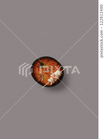 Top-Down View Spicy Thai Tom Yum Soup with Shrimp Skewer, Lime, and Kaffir Leaves in a Black Bowl on a Minimalist Gray Background Perfect for Food Blogs, Restaurant Menus, and Culinary Top-Down View Spicy Thai Tom Yum Soup with Shrimp Skewer, Lime, and Kaffir Leaves in a Black Bowl on a Minimalist Gray Background Perfect for Food Blogs, Restaurant Menus, and Culinary 122611480