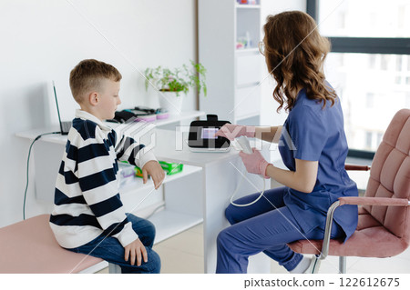 Boy testing breathing function by spirometry in doctors office. Diagnosis of respiratory function in pulmonary disease 122612675