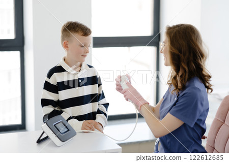 Boy testing breathing function by spirometry in doctors office. Diagnosis of respiratory function in pulmonary disease 122612685