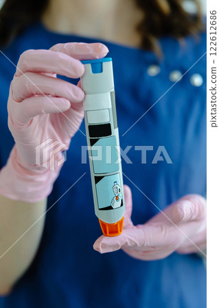 Doctor is demonstrating auto-injector syringe as an emergency treatment for allergic reaction 122612686