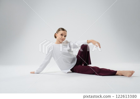 Girl performing a graceful dance pose in a studio setting 122613380