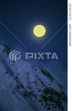 Celestial landscape with bright full disc-shaped moon above rocky mountainside. Celestial landscape with bright full disc-shaped moon above rocky mountainside. 122613620