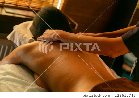 A female masseur massages a woman's back and neck. A female masseur massages a woman's back and neck. 122613715