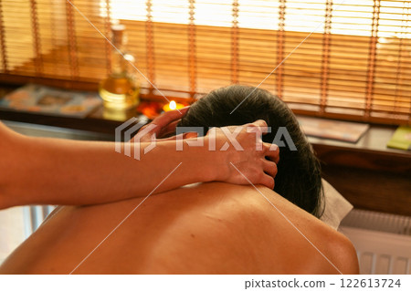 A female masseur massages a woman's back and neck. A female masseur massages a woman's back and neck. 122613724