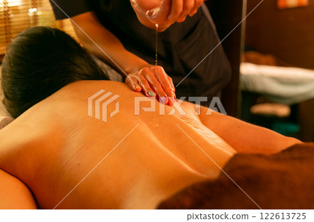 A female masseur massages a woman's back and neck. A female masseur massages a woman's back and neck. 122613725