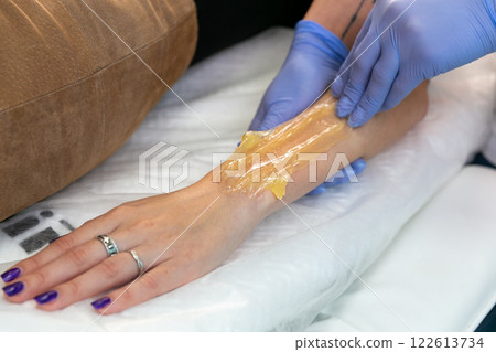 Procedure of hair removing on arm beautiful woman with sugar paste or wax honey Procedure of hair removing on arm beautiful woman with sugar paste or wax honey 122613734