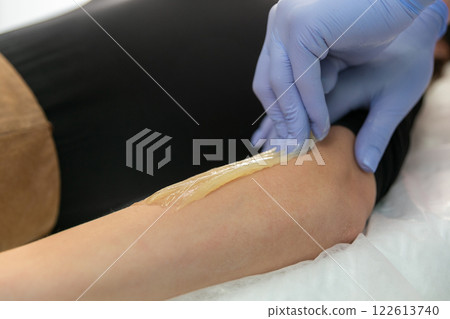 Procedure of hair removing on arm beautiful woman with sugar paste or wax honey 122613740