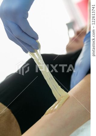 Procedure of hair removing on arm beautiful woman with sugar paste or wax honey Procedure of hair removing on arm beautiful woman with sugar paste or wax honey 122613741