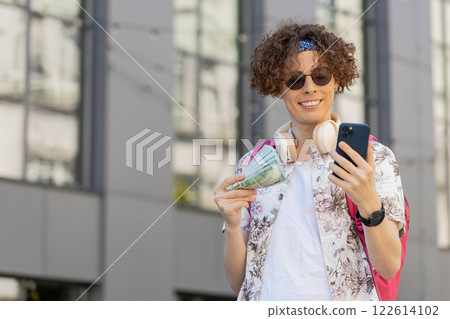 Happy rich tourist man counting holding money dollar cash, use smartphone calculator app outdoors Happy rich tourist man counting holding money dollar cash, use smartphone calculator app outdoors 122614102