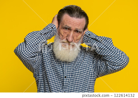 Annoyed irritated senior man covering ears gesturing no avoiding advice ignoring noise loud voices 122614132