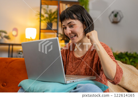 Woman using laptop, receive good news shocked by sudden victory celebrate lottery jackpot win Woman using laptop, receive good news shocked by sudden victory celebrate lottery jackpot win 122614165