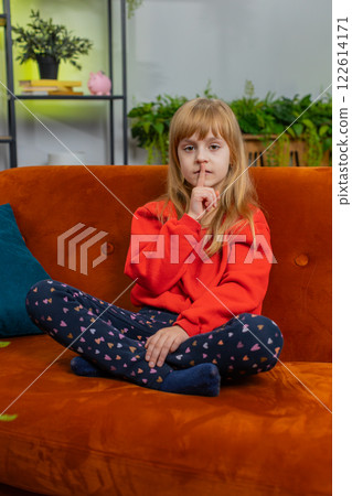 Preteen child girl presses finger to lips makes silence hush sign do not tell gossip secret, quiet 122614171