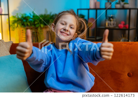 Happy child kid girl looking approvingly at camera showing thumbs up, like positive sign, good news 122614173