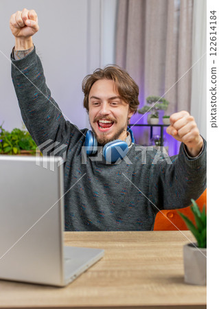 Amazed Caucasian man use laptop computer, receive good news message shocked by victory celebrate win 122614184