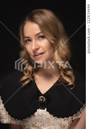 Beautiful blonde in a dress, portrait on a black Beautiful blonde in a dress, portrait on a black 122614444