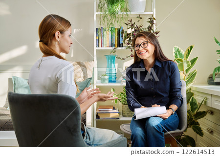 Female psychologist having therapy session with young woman 122614513