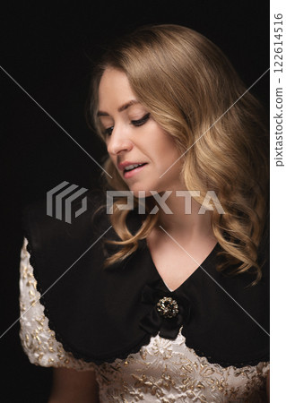 Beautiful blonde in a dress, portrait on a black Beautiful blonde in a dress, portrait on a black 122614516