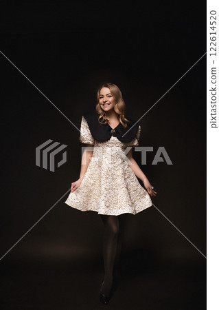 Beautiful blonde in a dress, portrait on a black Beautiful blonde in a dress, portrait on a black 122614520