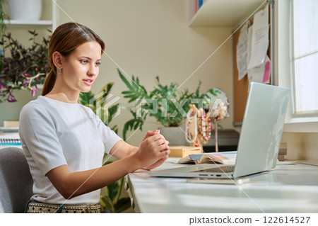 Girl teenage student having video chat online on computer Girl teenage student having video chat online on computer 122614527
