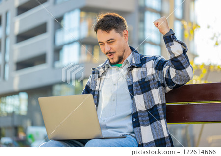 Overjoyed happy mature man working on laptop netbook screaming in delight on bench in downtown city Overjoyed happy mature man working on laptop netbook screaming in delight on bench in downtown city 122614666