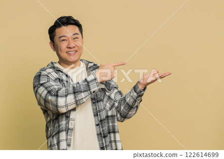 Asian man showing thumbs up and pointing on blank space place for advertisement promotion logo Asian man showing thumbs up and pointing on blank space place for advertisement promotion logo 122614699