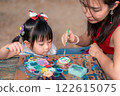 Asian Mother and Asian Daughter Painting Together in an Outdoor Art Workshop with Creative Atmosphere 122615075