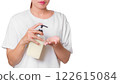 Woman in White Shirt Using Pump Bottle to Dispense Cream on Palm for Skincare Routine 122615084