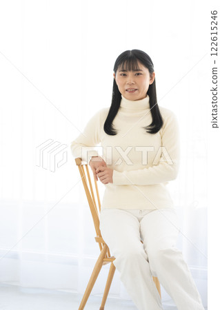 坐在椅子上,對著鏡頭微笑的女人 坐在椅子上,對著鏡頭微笑的女人 122615246
