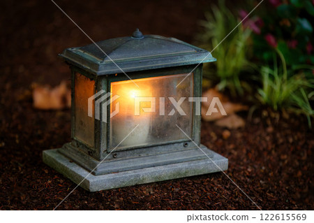 close-up of an old-fashioned grave lantern with a burning candle on a grave at dusk close-up of an old-fashioned grave lantern with a burning candle on a grave at dusk 122615569