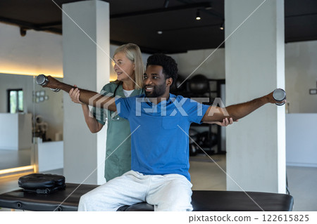 Female physical therapist having a session of exercises with a male patient 122615825
