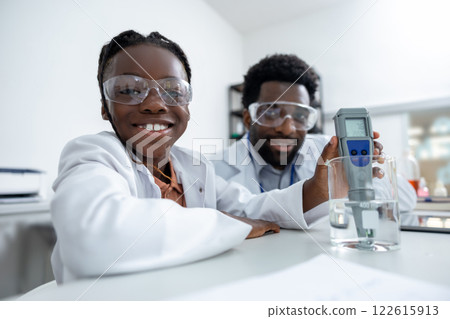 Teacher and student working in a school laboratory and looking involved and focused Teacher and student working in a school laboratory and looking involved and focused 122615913