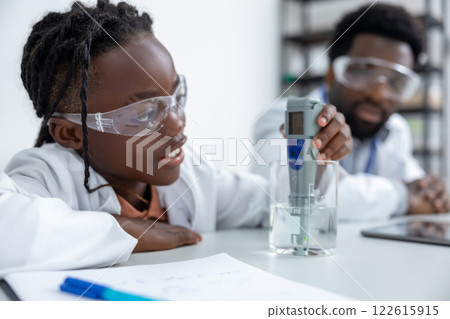 Teacher and student working in a school laboratory and looking involved and focused Teacher and student working in a school laboratory and looking involved and focused 122615915