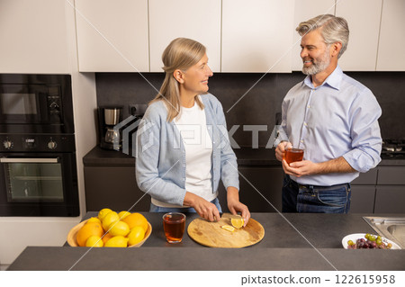 Senior couple enjoying breakfast and conversation at home together at kitchen 122615958