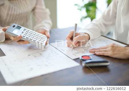 The hands of two women signing a real estate contract The hands of two women signing a real estate contract 122616012