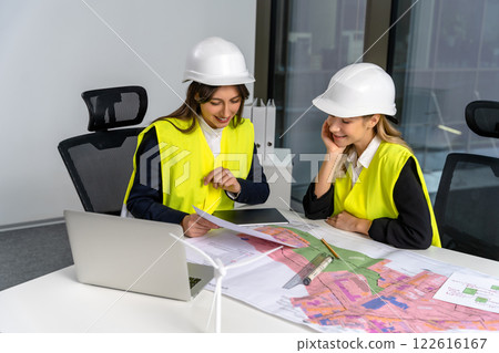 Two female engineers looking involved and excited while working together on the project Two female engineers looking involved and excited while working together on the project 122616167