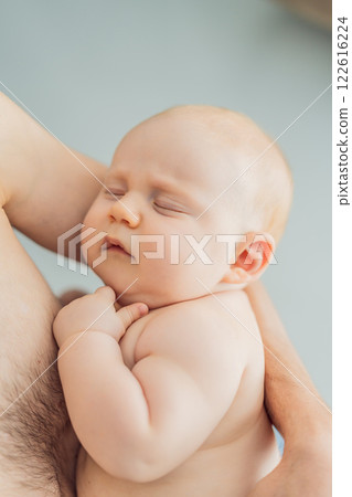 A baby peacefully falls asleep in his father's arms, skin-to-skin. A heartwarming and intimate moment of love, bonding, and parenthood, showcasing the deep connection between father and child A baby peacefully falls asleep in his father's arms, skin-to-skin. A heartwarming and intimate moment of love, bonding, and parenthood, showcasing the deep connection between father and child 122616224